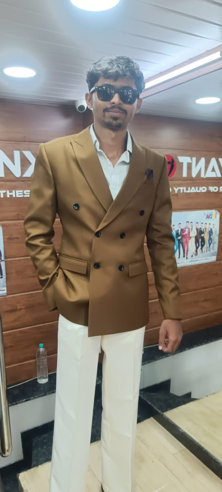 A camel double-breasted suit with cream trousers, cut at Jayant NX